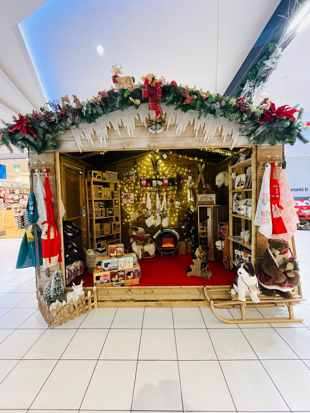 Overdekte kerstmarkt met versierde houten chalet